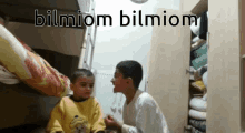 two young boys are standing next to each other with the words bilmiom bilmiom written above them