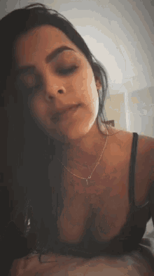 a woman is wearing a bra and a necklace with the letter y on it