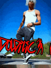 a man in a white tank top is doing a trick in front of a sign that says " voltica "