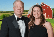 a man and woman pose in front of a barn