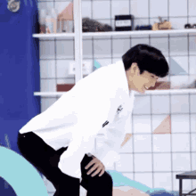 a man in a white shirt is kneeling down and smiling
