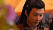 a young man with long hair is standing in front of a crowd and crying .