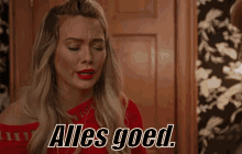 a woman in a red dress is making a funny face and saying alles goed .