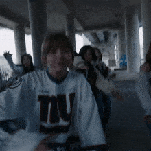 a woman wearing a new york giants jersey dancing
