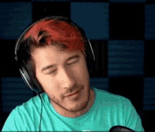 a man with red hair wearing headphones and a blue shirt .