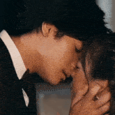a man in a suit kisses a woman on the forehead