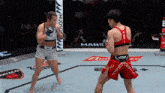 two women are fighting in a boxing ring and one of them has a venum tank top on