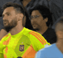 a man wearing a yellow shirt with a lm logo