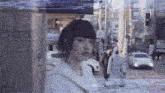 a woman walking down a street with a sign that says kin