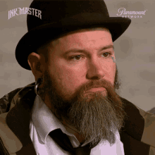 a man with a beard is wearing a hat that says ink master on it