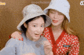 two girls wearing hats are standing next to each other and the words soochaeng are on the bottom right
