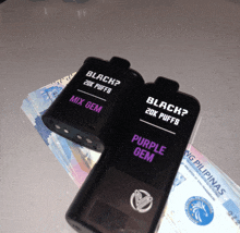 a purple gem and a black gem are on a pile of money