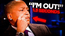 a man in a suit and tie is sitting in front of a sign that says `` i 'm out 1.3 seconds '' .