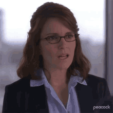 a woman wearing glasses and a suit makes a funny face .