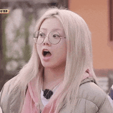 a blonde woman wearing glasses and a pink jacket says ooo !!