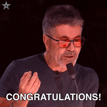 a man speaking into a microphone with the words congratulations written below him