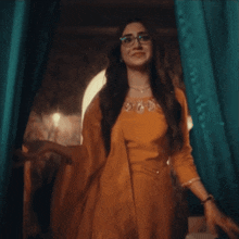 a woman wearing glasses and a yellow dress