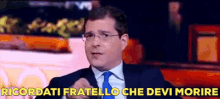 a man in a suit and tie says " ricordati fratello che devi morire " while pointing