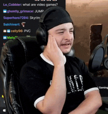 a man wearing headphones and a headband is sitting in front of a computer .
