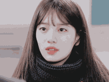 a close up of a woman 's face with a blue scarf on