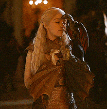 a woman with long blonde hair is holding a small dragon