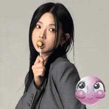 a woman in a suit is holding a yellow lollipop
