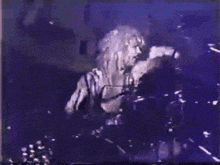 a woman playing drums in a dark room