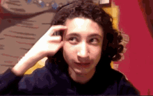 a person with curly hair is wearing headphones and making a funny face