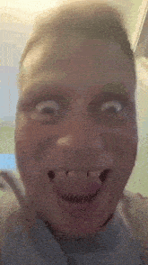 a close up of a man making a funny face with his tongue out and missing teeth .