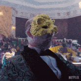 a man in a tuxedo is wearing a gold mask with a lion face on it