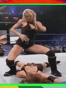 two women are wrestling in a ring and one of them is wearing shorts