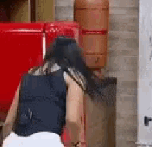 a woman is standing next to a red refrigerator in a kitchen .