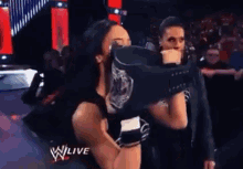 a woman is kissing a man on the cheek during a wrestling match on a tv show .