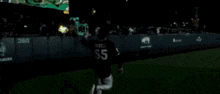 a baseball player wearing a number 55 jersey is running on the field