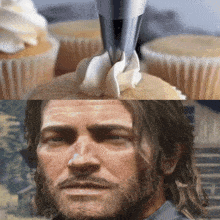 a man with a beard looks at a cupcake with whipped cream on top