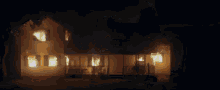 a house is on fire at night with a man on the porch