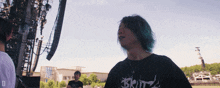 a man wearing a shirt that says britz stands in a field
