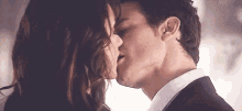 a man and a woman are kissing each other on the cheek .