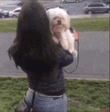 a woman is holding a small white dog in her arms with starr written on the bottom
