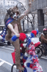 a man riding a bike with a clown on the back of it