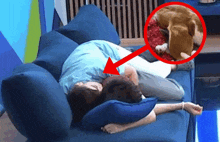 a person laying on a couch with an arrow pointing at a dog