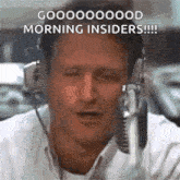 a man wearing headphones is talking into a microphone and saying `` good morning insiders '' .