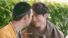 two men are kissing each other on the cheek and one of them is smiling .