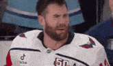 a hockey player with a beard is crying while wearing a white jersey with the number 50 on it .