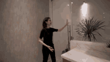 a woman in a black shirt is standing in front of a glass door .