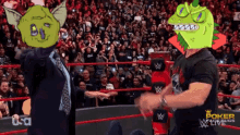 a man in a suit and tie stands in a wrestling ring with a mask on his head that says poker facebugs live
