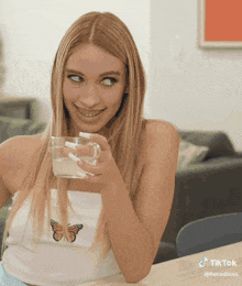 a woman sitting at a table with a cup of milk in her hand .
