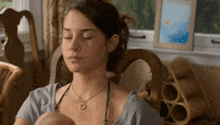 a woman is sitting in a chair with her eyes closed and holding a baby .