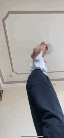 a man wearing a white shirt and black pants is standing in a room