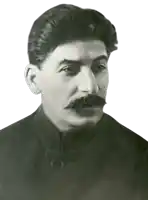 a man with a mustache wearing a black coat